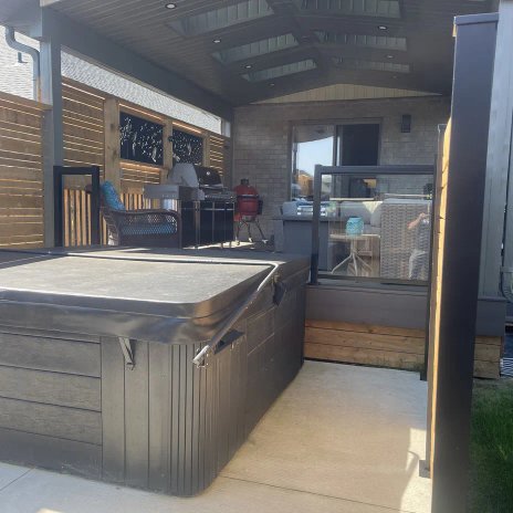 Covered outdoor living area with hot tub